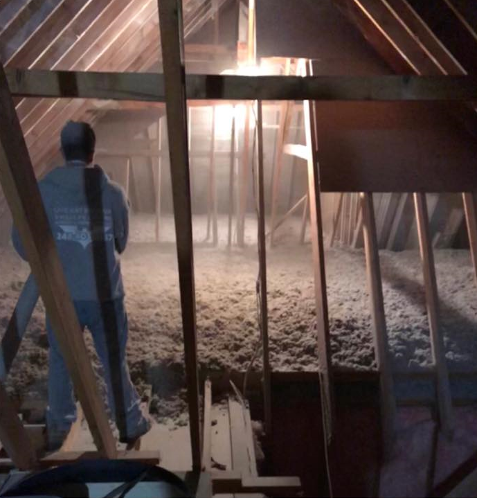 man standing in attic looking at damages